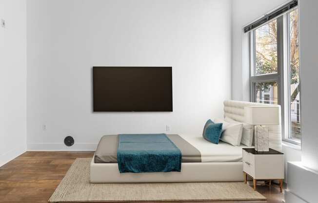 a bedroom with a bed and a tv on the wall
