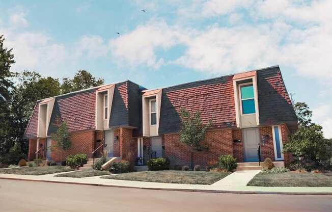 a brick house with a sidewalk in front of it