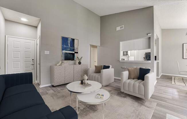 A living room with a dark blue sofa and a white coffee table.