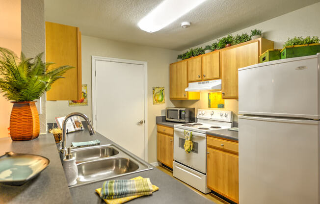 A kitchen with a white refrigerator, stove, and oven.