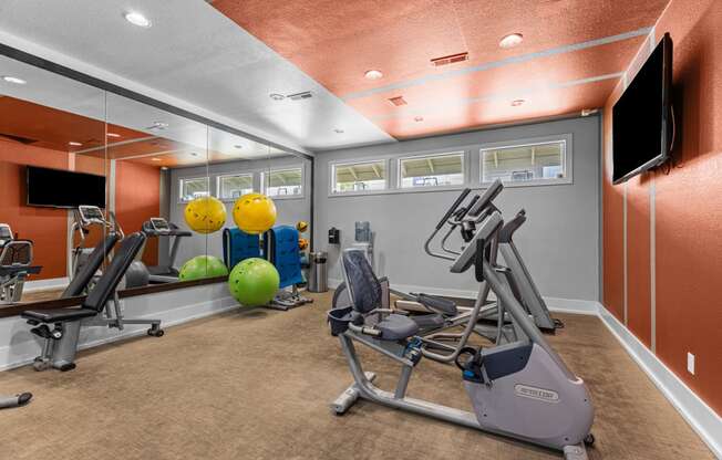 a gym with weights and other exercise equipment and a television