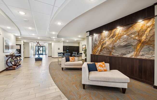 a lobby with couches and chairs and a large painting on the wall