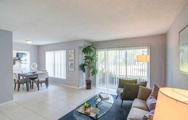 A living room with a couch, coffee table, and dining table.