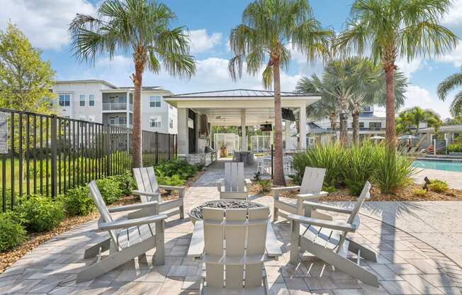an outdoor patio with chairs and palm trees at Drift, Daytona Beach, FL, 32117