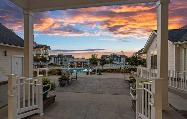 a view of a patio with a pool at sunset