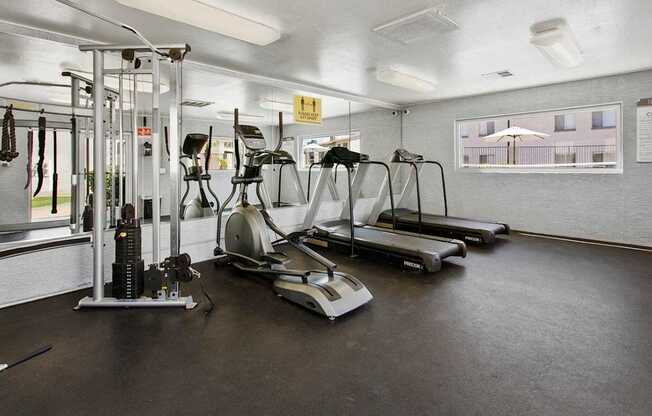 A gym with treadmills, elliptical machines, and other exercise equipment.