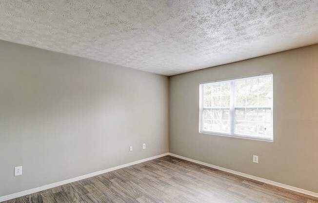 A room with a window and wooden flooring.