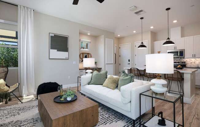 A modern living room with a white sofa and a wooden coffee table.