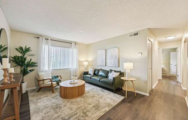 A living room with a green couch, a wooden coffee table, and a rug.