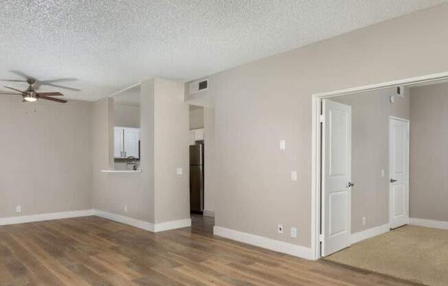 A room with a ceiling fan and wooden flooring.