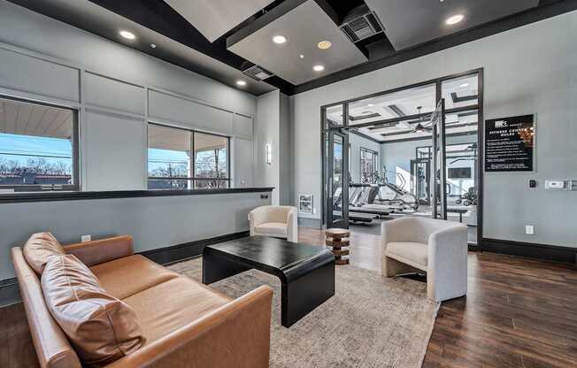 A modern living room with a brown leather couch and a black coffee table.