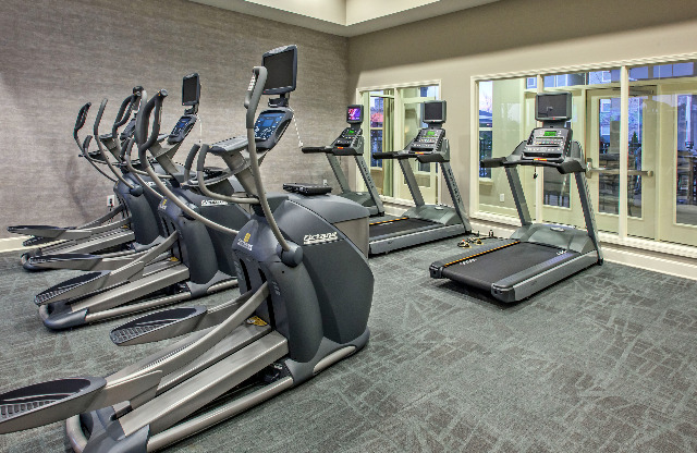 Fitness center featuring treadmills and elliptical machines.