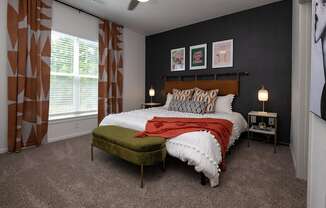 a bedroom with a bed and a chair in front of a window
