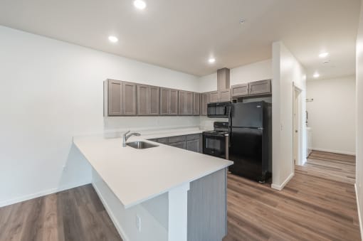 a kitchen with a white counter top and a black refrigerator at Gateway Apartments, Washington