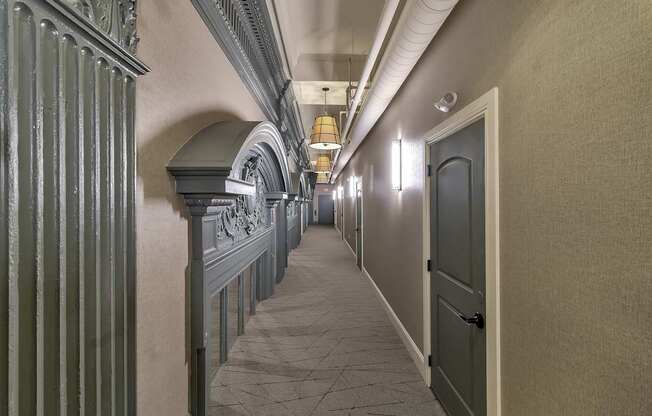 a long hallway with a door and columns on the side at The Knights @ 506 Delaware Apartments, New York, 14202