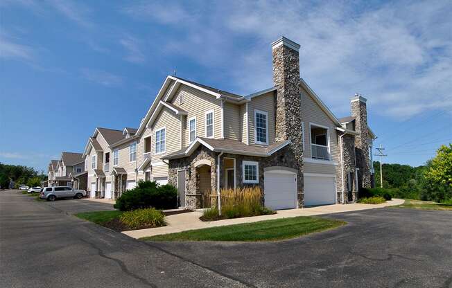 a house with a stone chimney and a white garage door