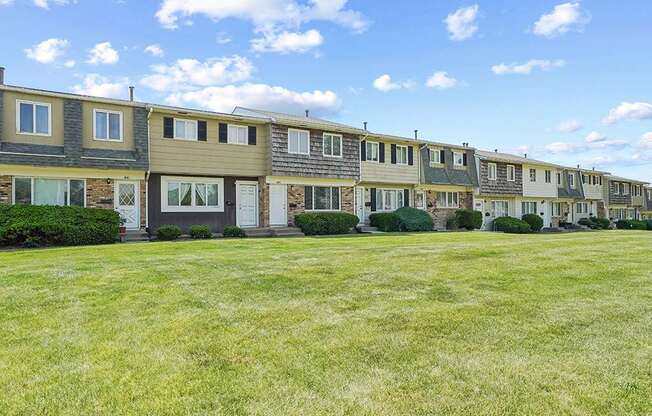 A row of houses with green lawns in front.