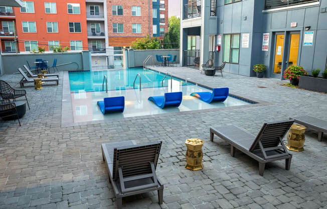 a pool of water in a courtyard with benches and chairs