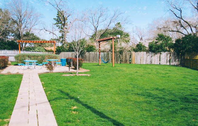 a backyard with a picnic area and a swing set