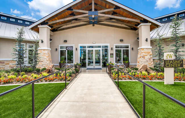The image shows the front of a leasing center with a clear blue sky in the background.