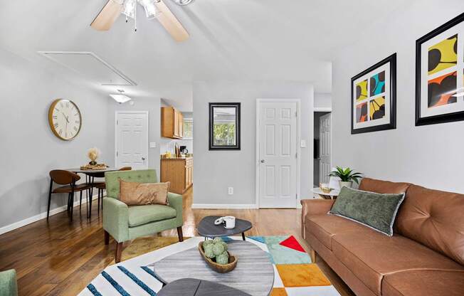 A living room with a brown couch, a green chair, and a wooden table.