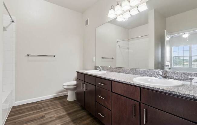 A bathroom with a toilet, sink, and mirror.