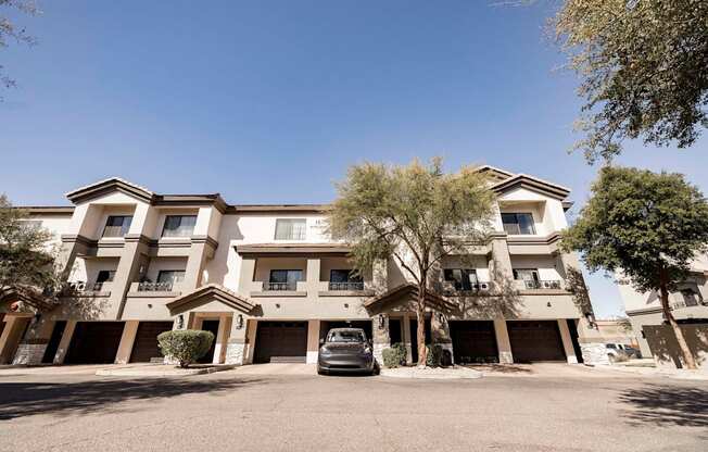 A large, multi-story building with a car parked in front.