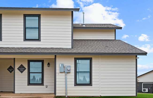 the front of a white house with a gray roof at Diamond Ridge Townhomes, Oklahoma