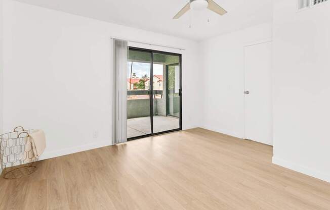 A room with a sliding glass door leading to a balcony.
