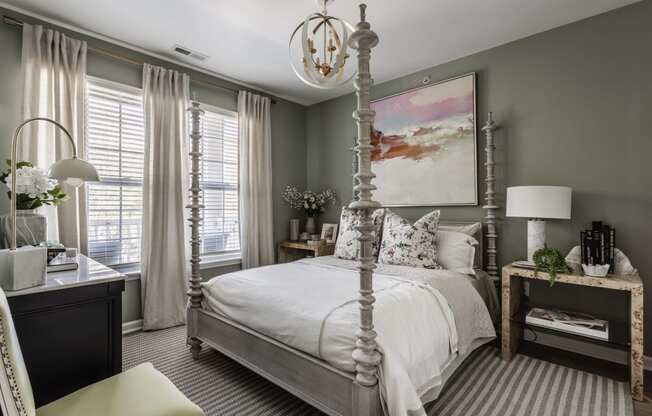 a bedroom with a white bed and a painting on the wall