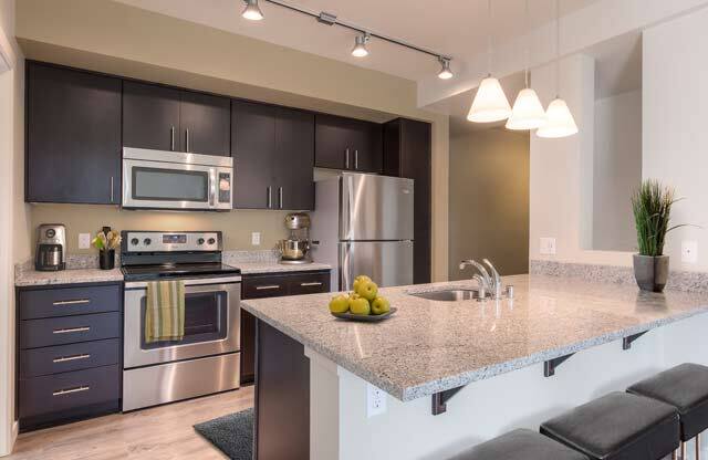 A kitchen with a stove, refrigerator, and microwave. at Kirkland Crossing Apartments, Washington