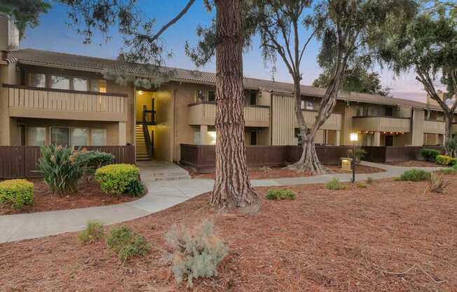 an apartment building with a courtyard and trees in front of it at Summerwood Apartments, California