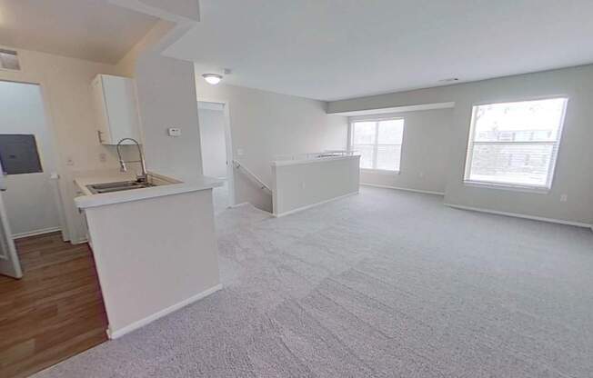 Open-concept living with spacious living area, large windows, and kitchen