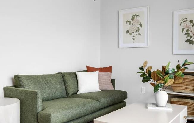 a living room with a green couch and a white coffee table