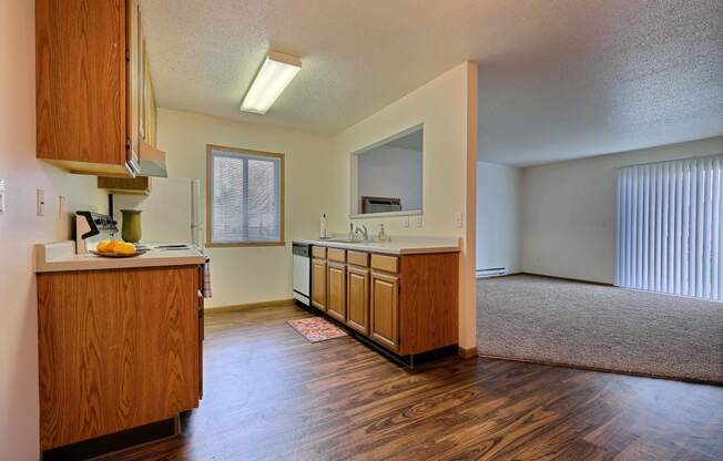 a kitchen with white appliances and wooden cabinets. Fargo, ND Oxford Apartments.