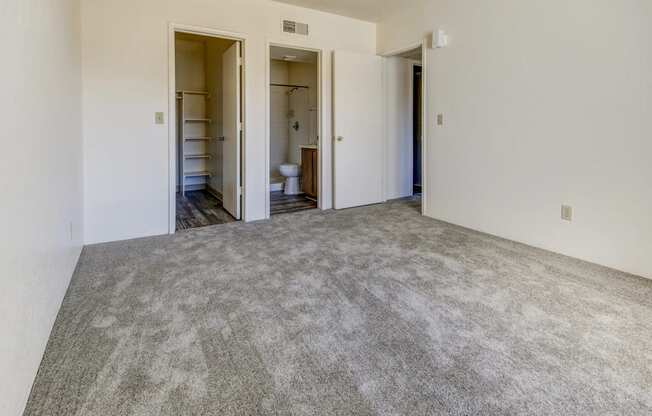 an empty room with white walls and a carpeted floor
