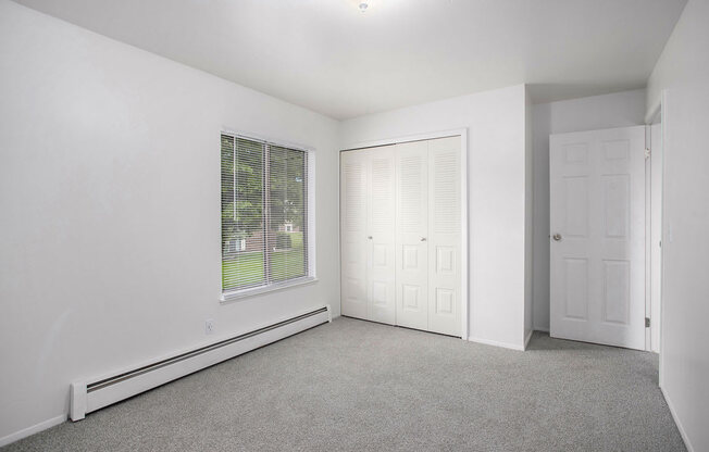 spacious bedroom with a closet and large window