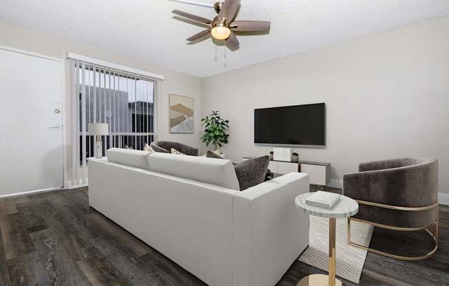 A living room with a white couch and a ceiling fan.