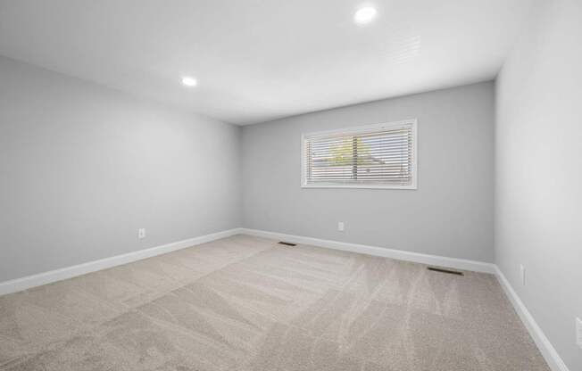 an empty room with white walls and a window on the wall