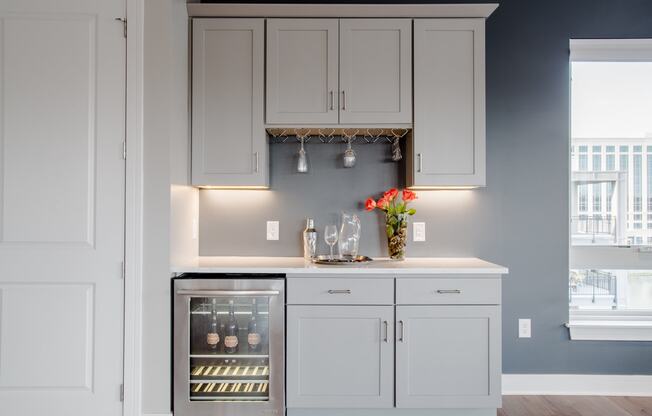 Built-in wine cabinet, neutral colored walls, ample lighting in luxury penthouse