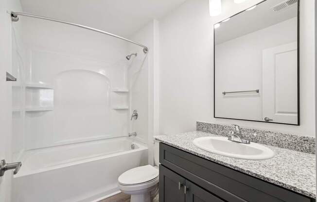 A white bathroom with a toilet, sink, and bathtub.