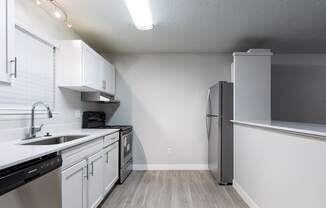 A kitchen with white cabinets and a black dishwasher.