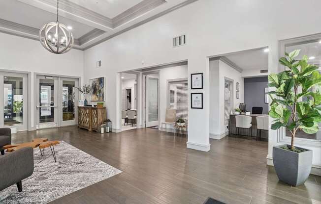 A leasing office with a grey sofa and a large rug at Encore at Buckingham Apartments in Richardson, TX