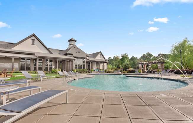 a resort style pool with lounge chairs and a building in the background