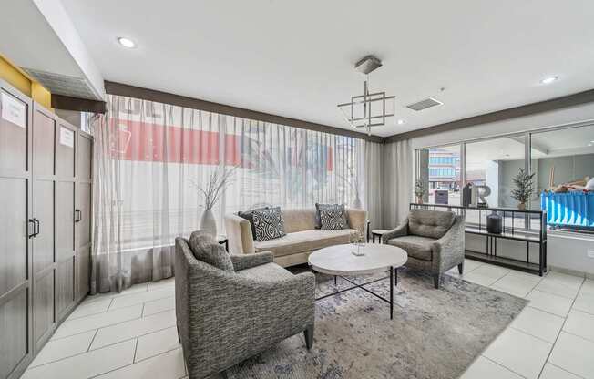 A living room with a grey sofa, a grey armchair, and a grey coffee table.