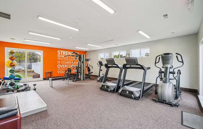 A gym with a variety of equipment including treadmills, stationary bikes, and weight machines.