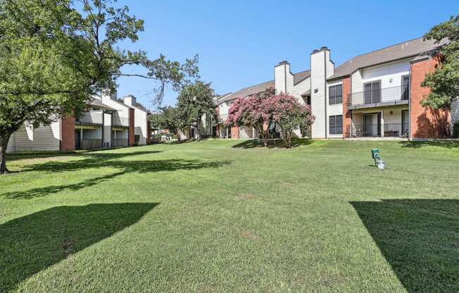 Lush green landscape with pet waste collection stations at Hunters Chase in Austin, TX