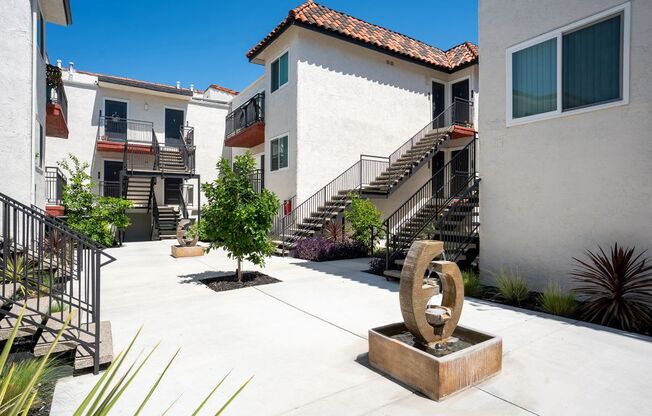 A courtyard with a sculpture in the middle of it.