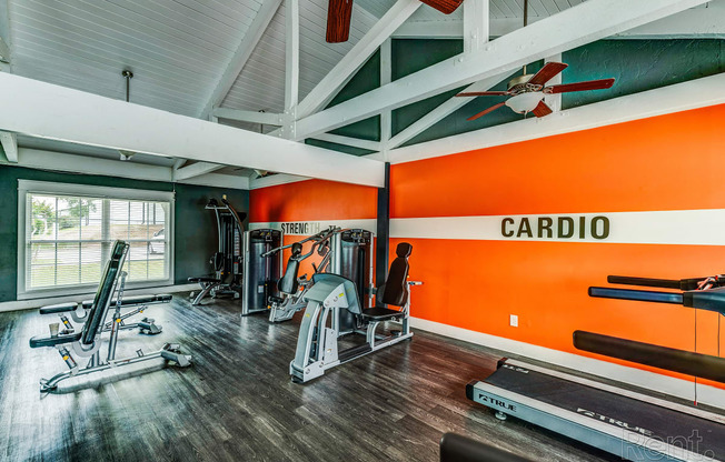 the home gym has plenty of exercise equipment and a large window