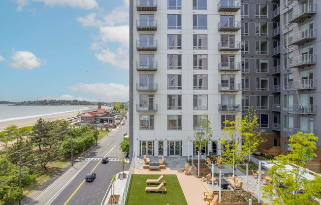 A view of a street with cars and apartment buildings.